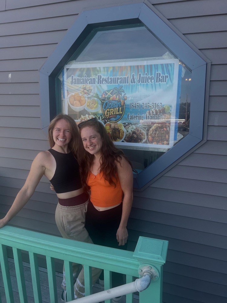 Customers smiling outside Ocean Grill with a to-go order